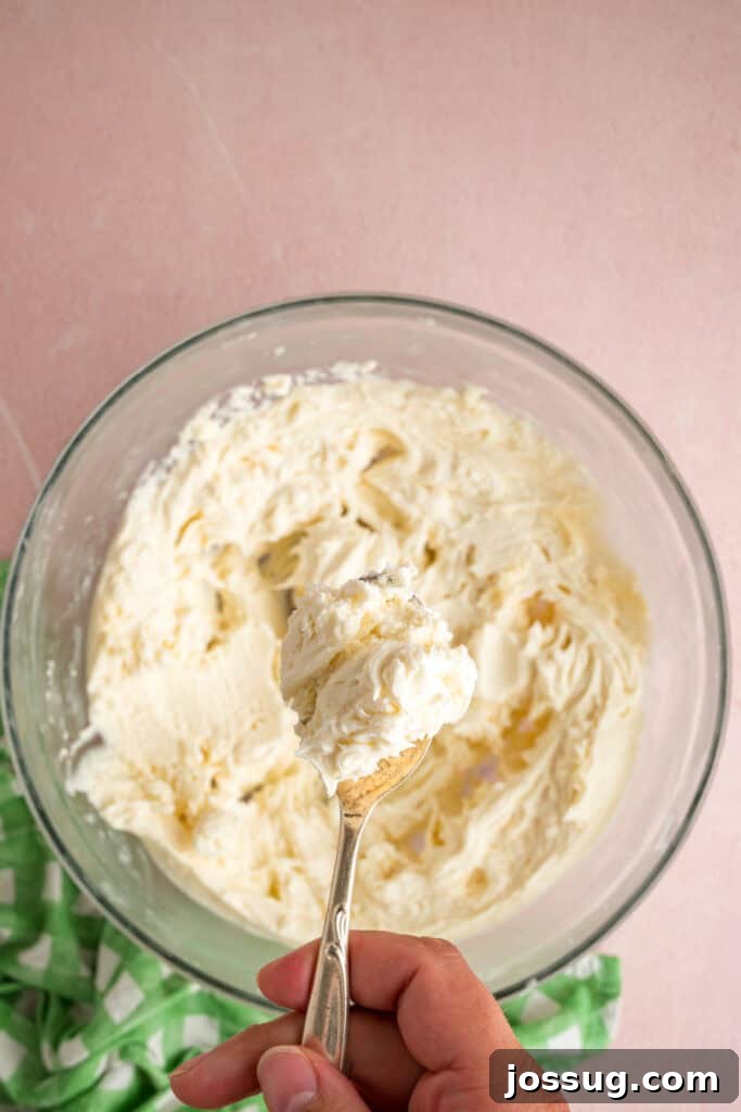 Buttercream Bliss Bites 10 Spoon holding a scoop of buttercream filling above the mixing bow
