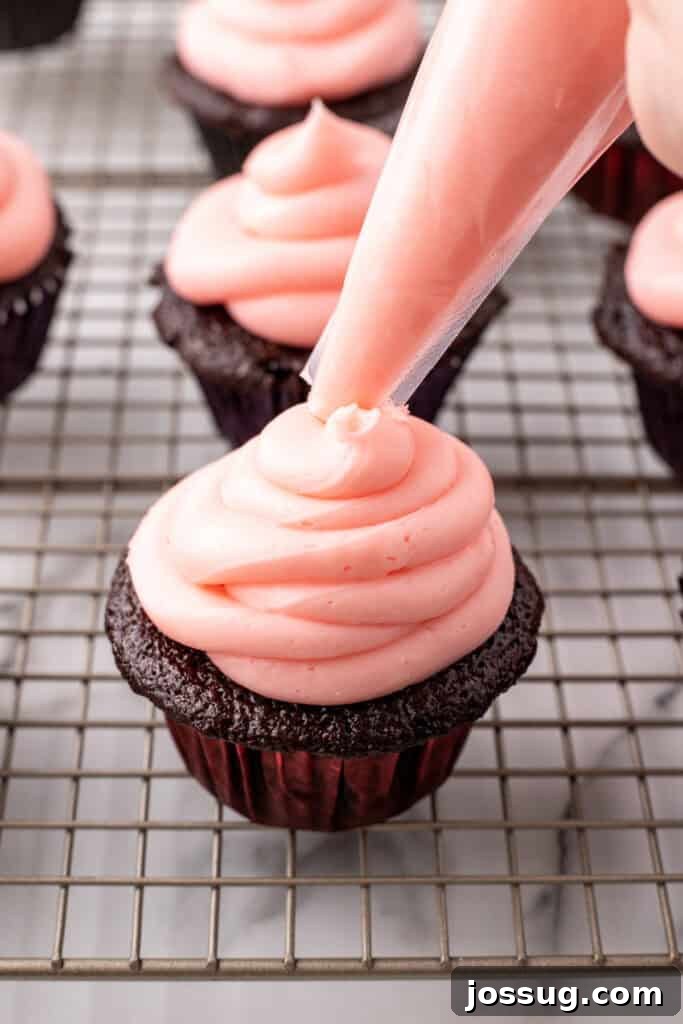 Piping Cherry Buttercream onto Cupcake
