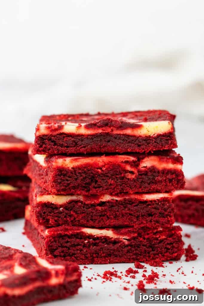 Stack of red velvet cheesecake brownies showing layers
