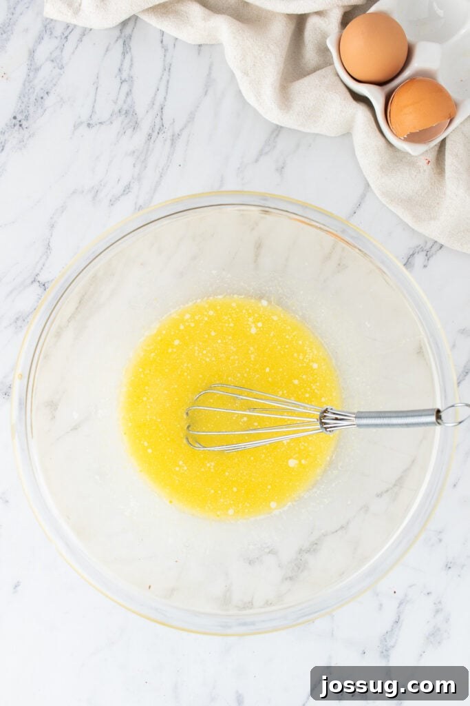 Melted butter mixture in a glass bowl with a whisk