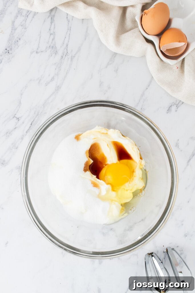 Glass bowl with cream cheese, sugar, egg, and vanilla