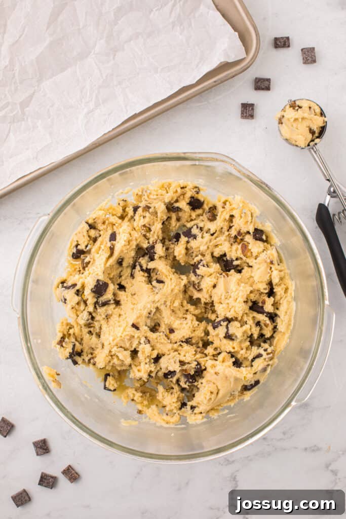 Pistachio Dream Cookies 7 Mixed pistachio chocolate chunk cookie dough with a cookie scoop.
