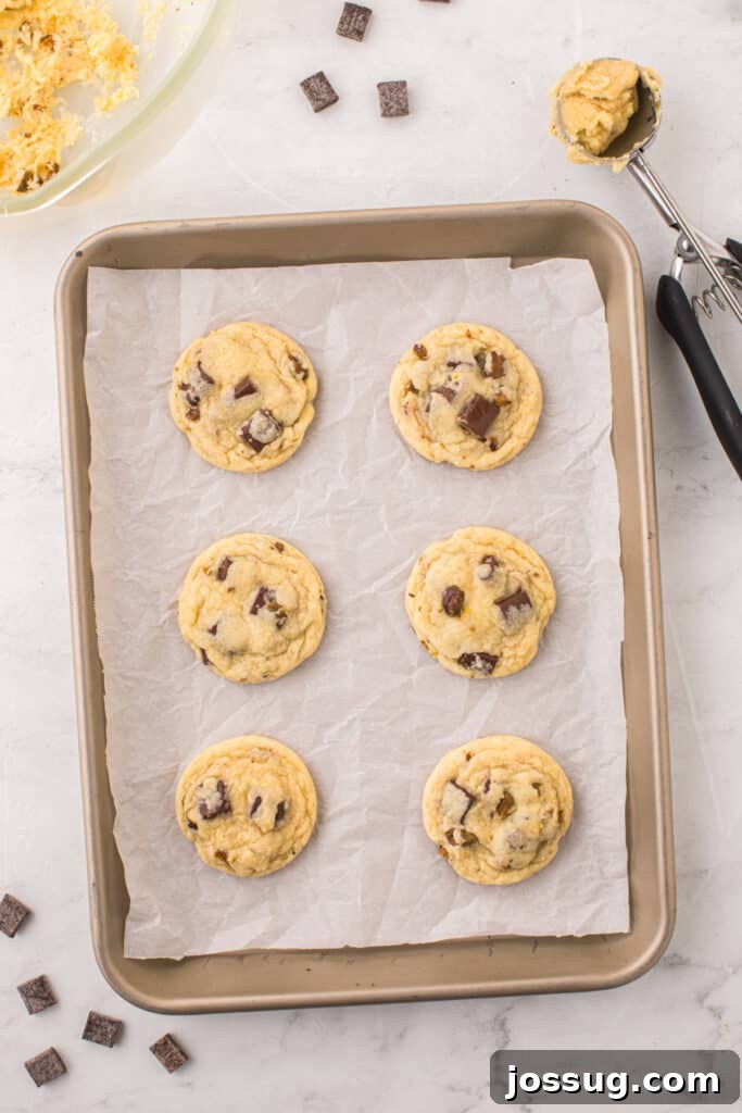 Pistachio Dream Cookies 9 Baked pistachio chocolate chunk cookies on a baking sheet.