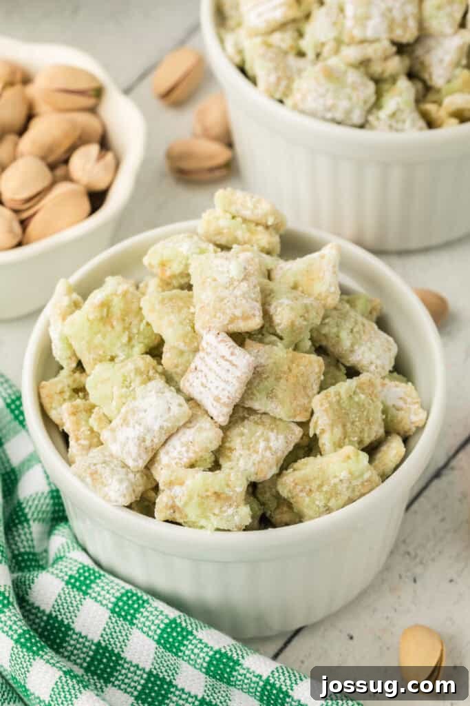 Pistachio Puppy Chow 2 Pistachio Muddy Buddies dusted with powdered sugar in a white ramekin