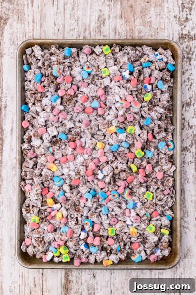 Powdered sugar-coated Rice Chex cereal with Lucky Charms marshmallows on a baking sheet