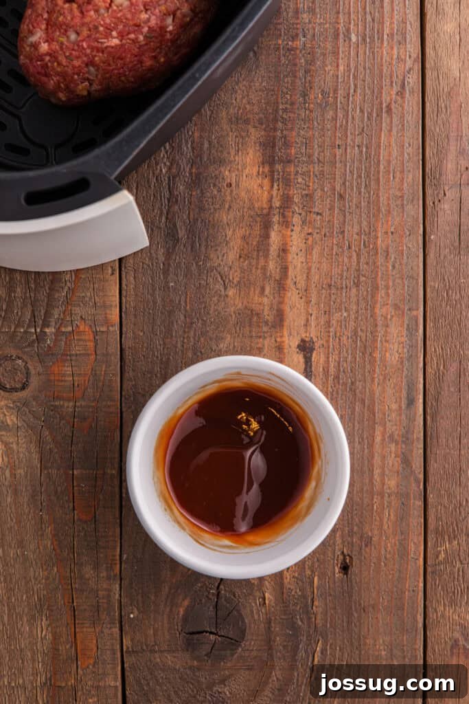 Small white bowl with blended ketchup glaze on a wooden surface.