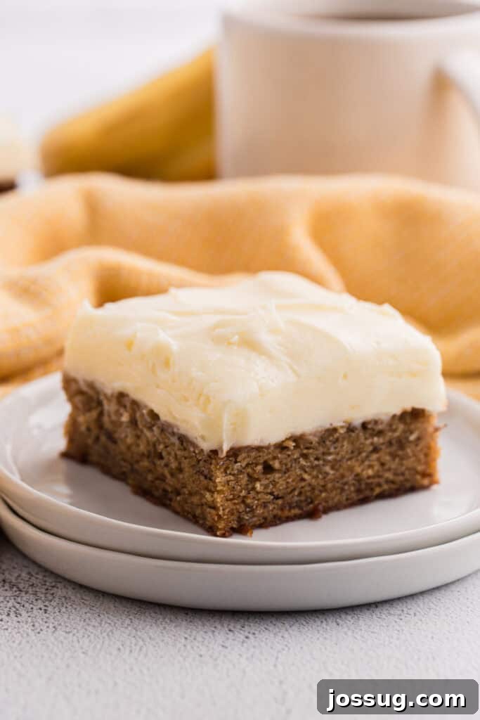 Banana Bread Brownies 2 Single banana brownie square with cream cheese frosting on a white plate