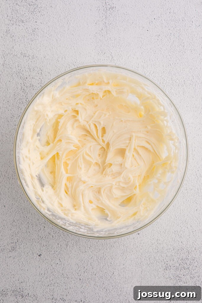 Banana Bread Brownies 13 Glass bowl filled with smooth cream cheese frosting on a light textured surface