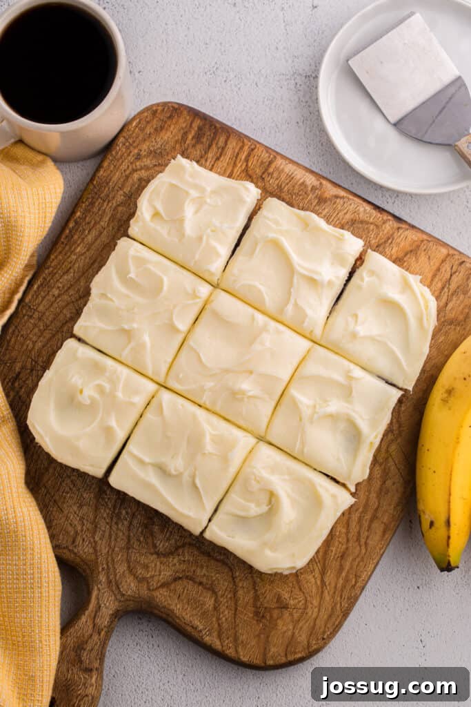 Banana Bread Brownies 15 Frosted banana brownies cut into squares on a wooden cutting board with a cup of coffee and bananas nearby