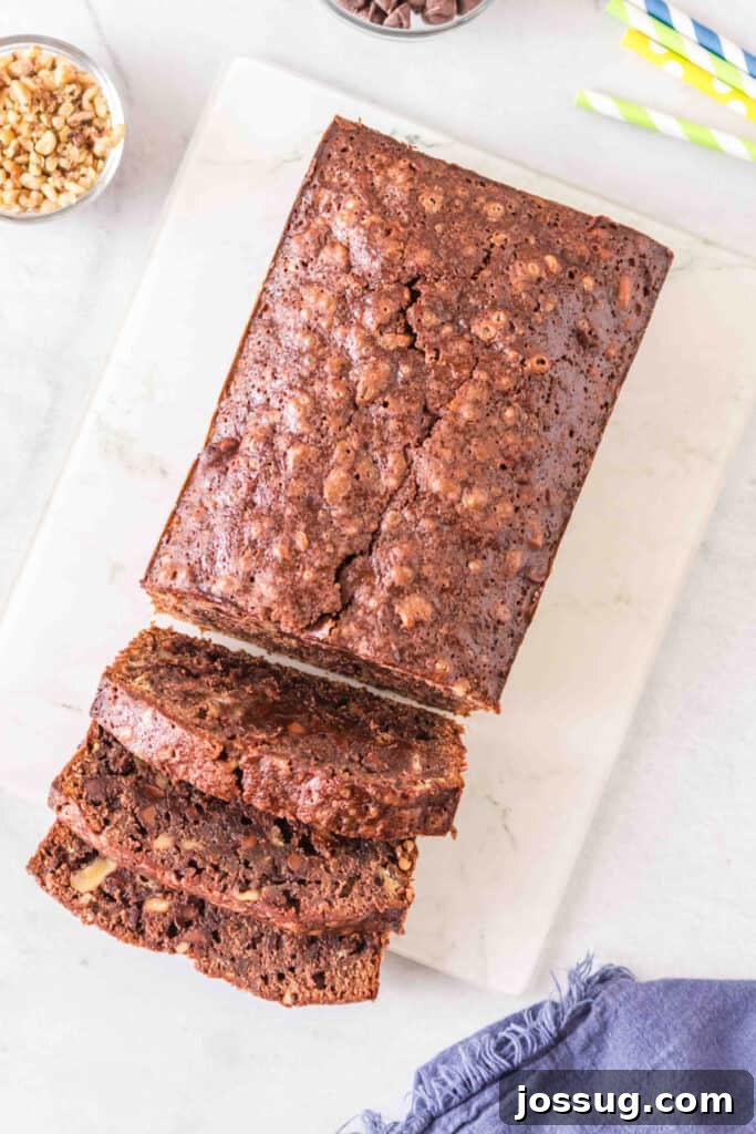 Brownie-Swirled Banana Bread 8 Whole brownie banana bread loaf on a white cutting board with several slices cut in front.