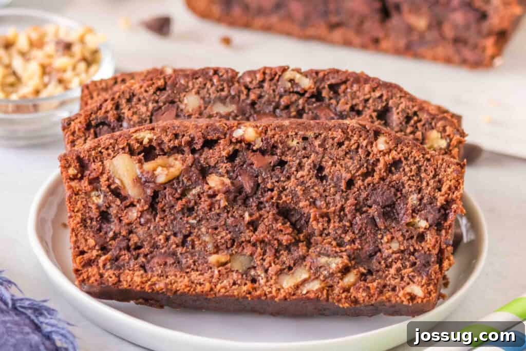 Brownie-Swirled Banana Bread 10 Two slices of brownie banana bread on a white plate with chocolate chips and walnuts visible.