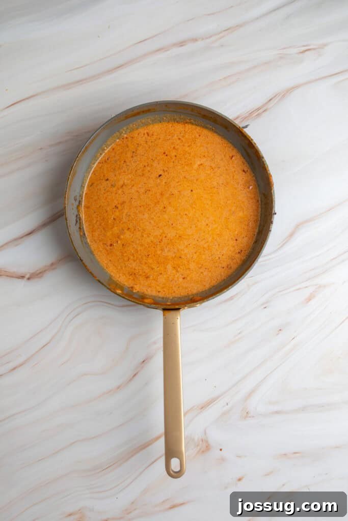 overhead view of a skillet filled with orange coconut curry sauce
