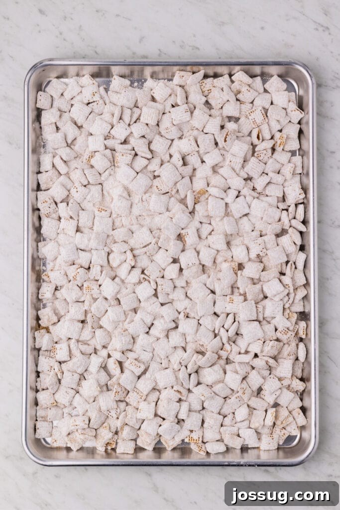 Carrot Cake Muddy Buddies: A Festive Spring Treat 11 Carrot cake muddy buddies spread on a baking sheet to cool