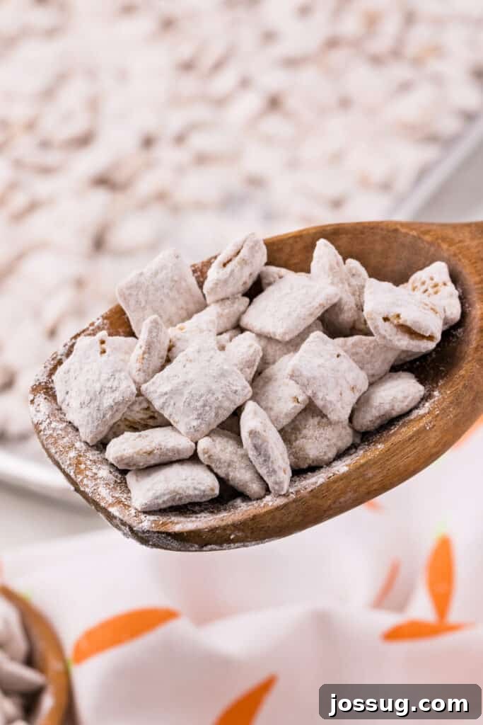 Carrot Cake Muddy Buddies: A Festive Spring Treat 13 Carrot cake muddy buddies in a wooden spoon with serving dish in background