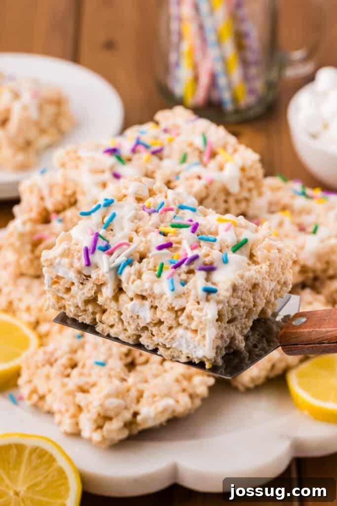 Lemon Rice Crispy Treat Lifted on a Spatula with White Drizzle and Sprinkles