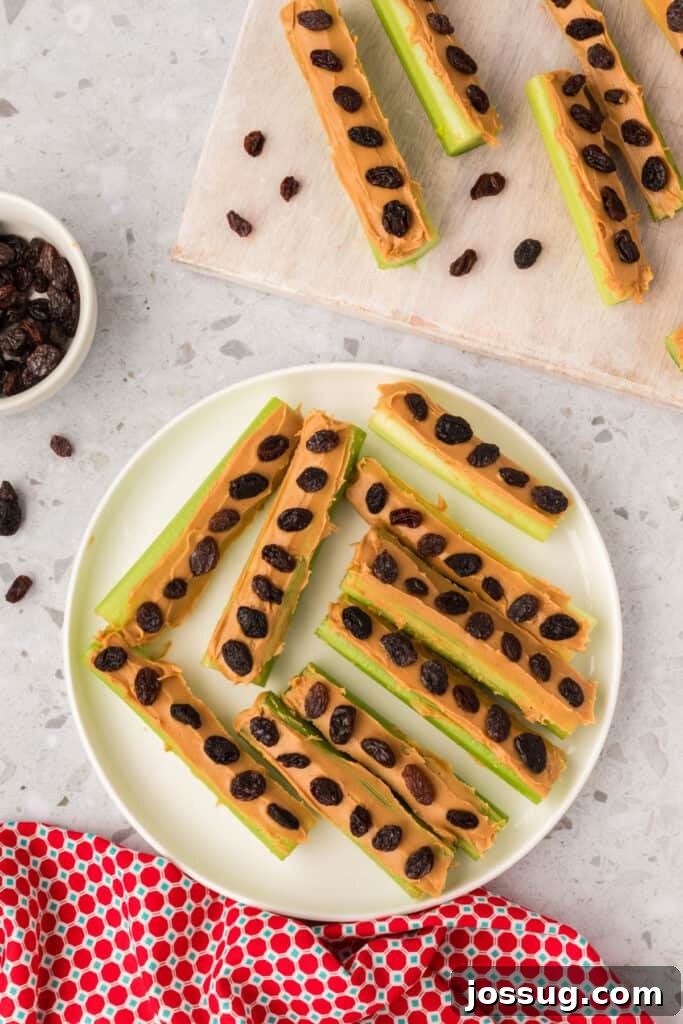 Ants on a Log: A Fun & Healthy Snack for Kids 7 Celery sticks topped with peanut butter and raisins arranged on a plate and cutting board