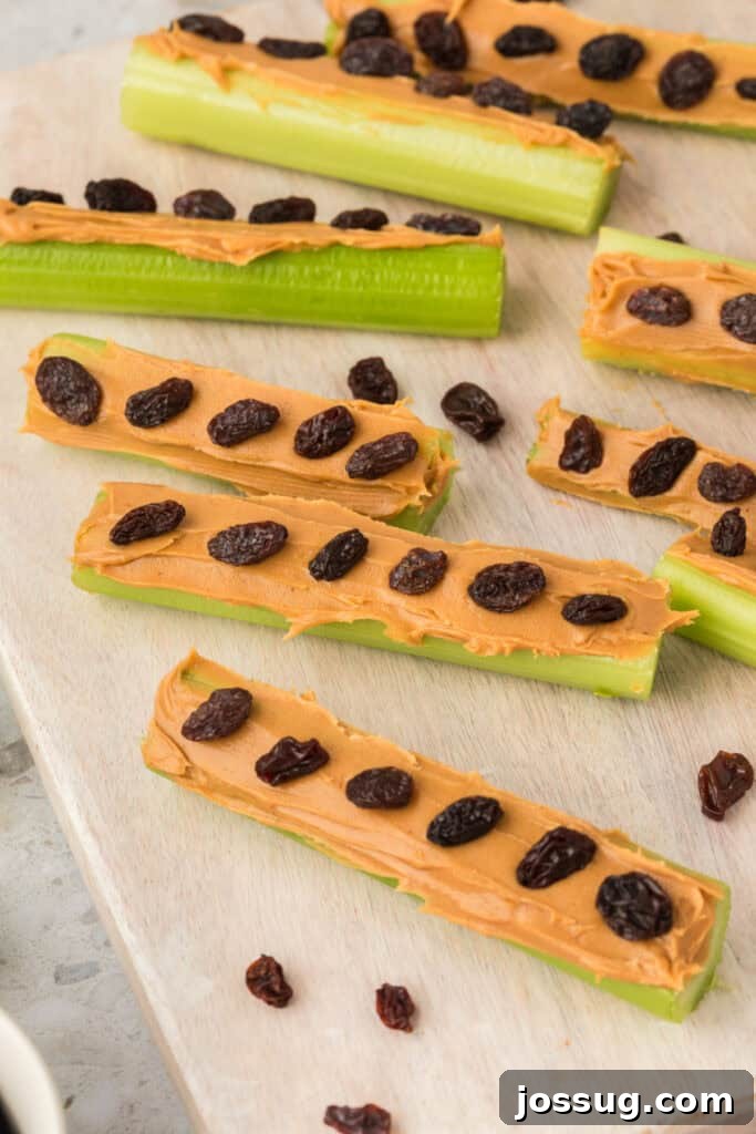 Ants on a Log: A Fun & Healthy Snack for Kids 8 Close up of celery sticks topped with peanut butter and raisins scattered on a board