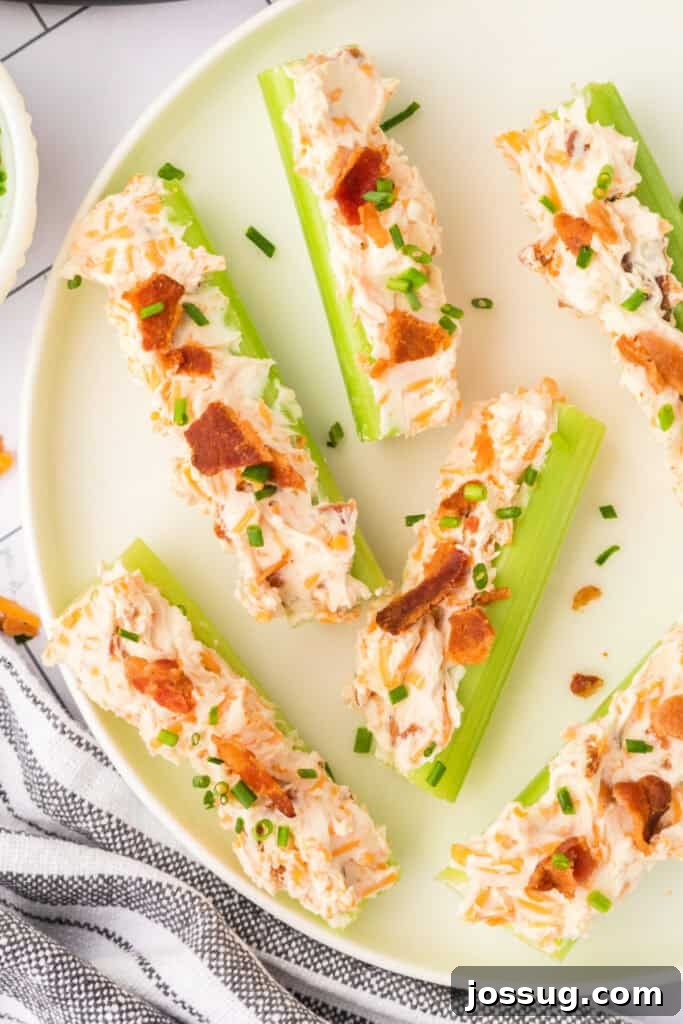 Overhead view of finished cheddar bacon celery sticks on a plate with scattered cheese and bacon pieces