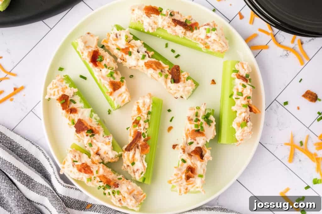 Finished cheddar bacon celery sticks topped with bacon and chives on a plate