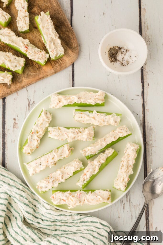 Celery sticks filled with cream cheese mixture arranged on a plate