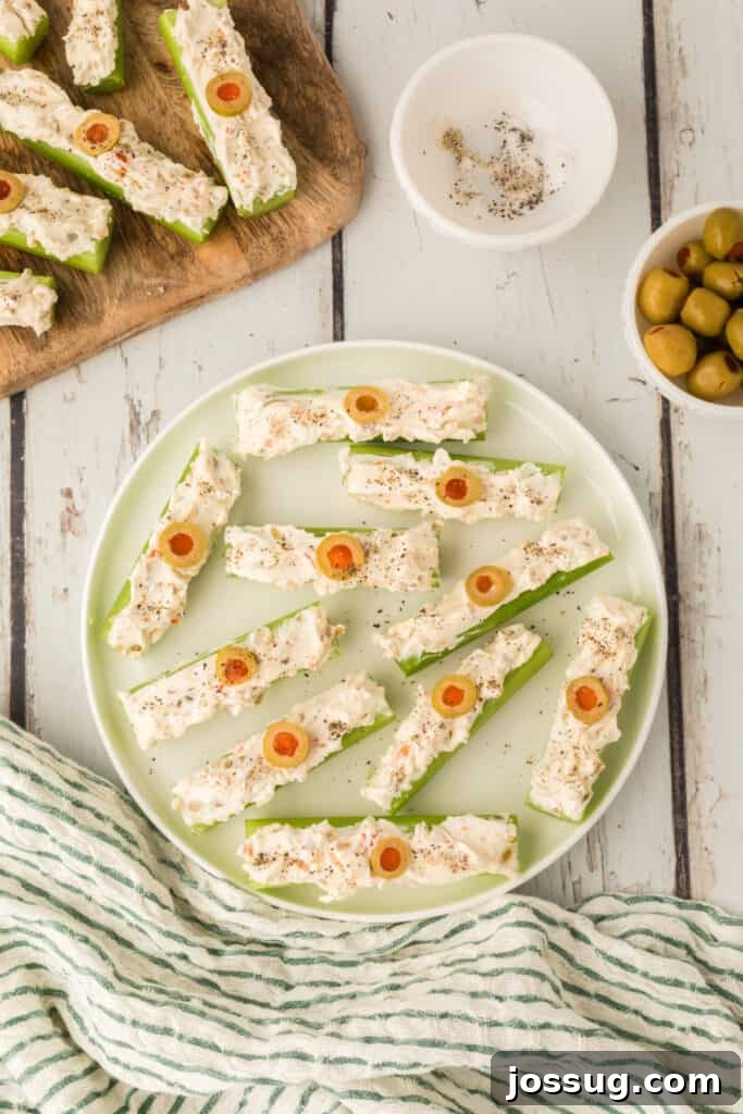 Celery sticks filled with cream cheese mixture topped with sliced olives and black pepper