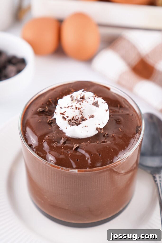 Chocolate Infused Custard Eggs 2 Chocolate pudding in a glass topped with whipped topping and chocolate shavings with eggs in the background
