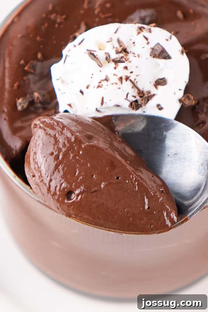 Chocolate Infused Custard Eggs 11 Spoonful of chocolate pudding with whipped topping and chocolate shavings in a glass cup