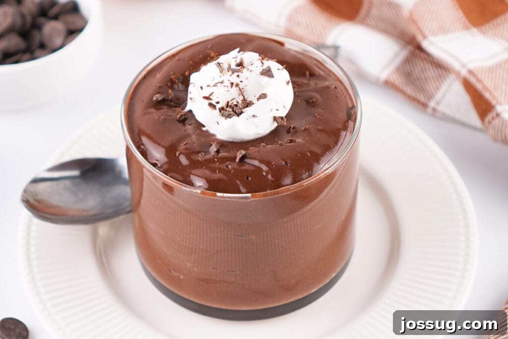 Chocolate Infused Custard Eggs 4 Glass of chocolate pudding topped with whipped topping and chocolate shavings on a white plate