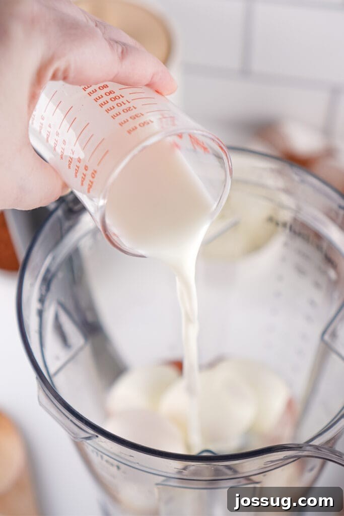 Chocolate Infused Custard Eggs 6 Milk being poured into a blender with hard boiled eggs