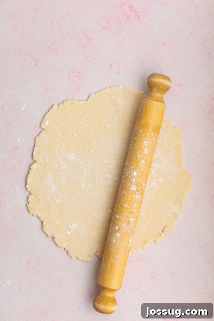 Simply Irresistible Strawberry Rhubarb Galette 12 Galette dough expertly rolled out into an appealingly rough circular shape on a lightly floured surface, with a rolling pin nearby, indicating readiness for the filling.