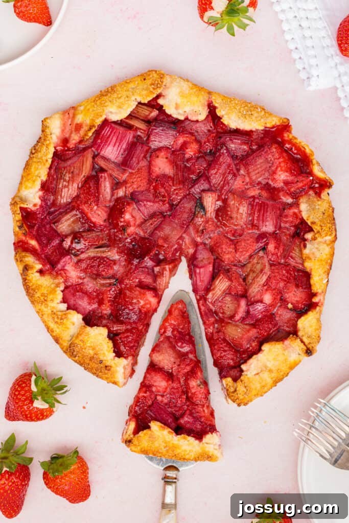 Simply Irresistible Strawberry Rhubarb Galette 21 A beautifully baked strawberry rhubarb galette, with one perfectly cut slice gently lifted on a pie server, showcasing the rich, vibrant fruit filling and its wonderfully flaky, golden-brown crust.