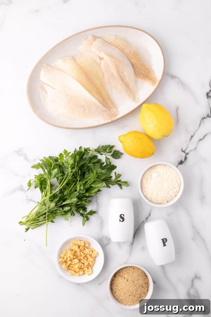 Raw flounder fillets on a plate surrounded by fresh lemons, parsley, minced garlic, breadcrumbs, and salt and pepper shakers on a marble surface, showing ingredients for baked fish.