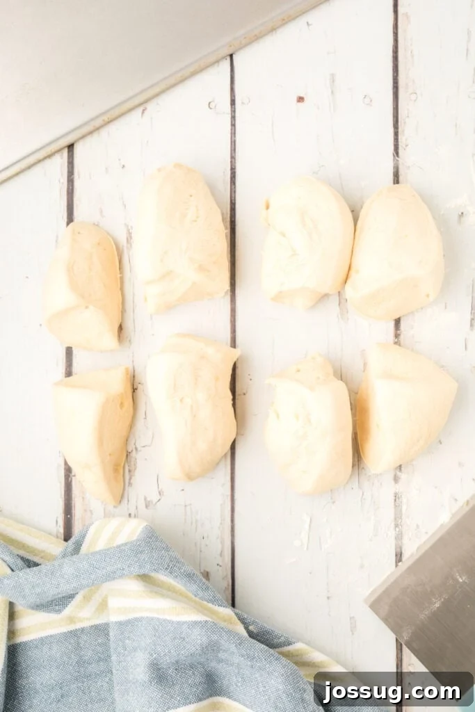 homemade onion rolls dough divided into 8 pieces on a floured surface