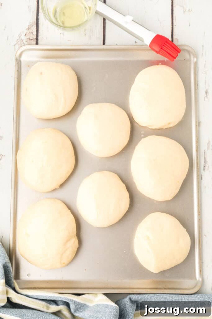 homemade onion rolls dough brushed with egg wash on a baking sheet before baking