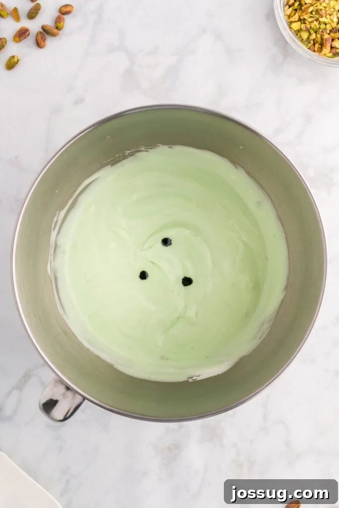 Quick No Bake Pistachio Delight 12 The green pistachio filling mixture, now perfectly combined, with a few extra drops of green food coloring being added to achieve a more vibrant hue.
