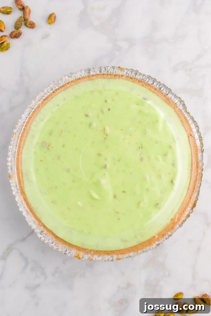 Quick No Bake Pistachio Delight 15 A freshly prepared No Bake Pistachio Cream Pie, with its smooth green filling covered, is ready to be placed in the refrigerator for chilling.