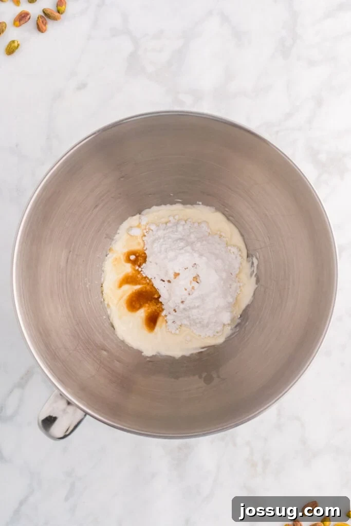 Quick No Bake Pistachio Delight 9 Softened cream cheese, powdered sugar, and vanilla extract are combined in a mixing bowl, ready to be beaten until light and fluffy.