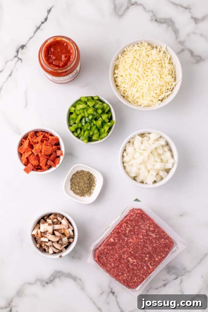 Easy Ground Beef Pizza Sloppy Joes 3 ingredients for Pizza Sloppy Joes including ground beef, chopped onion, green pepper, mushrooms, pepperoni, shredded mozzarella, pizza sauce, and dried oregano on a white surface