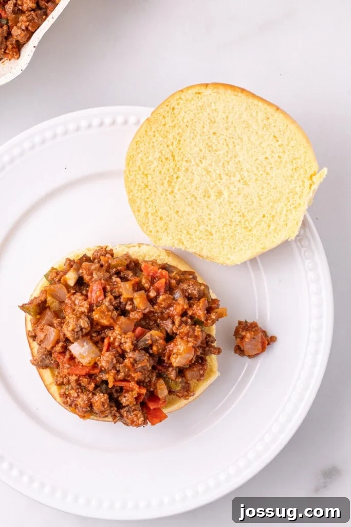 Easy Ground Beef Pizza Sloppy Joes 9 Pizza Sloppy Joes meat mixture spooned onto the bottom half of a hamburger bun on a white plate