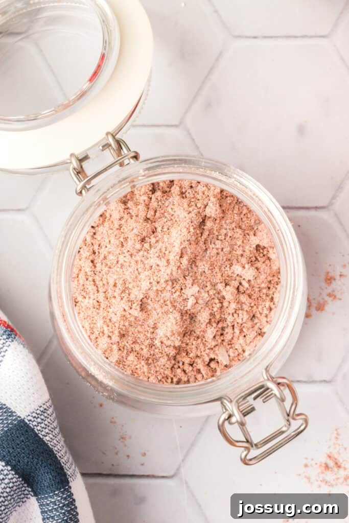 A sealed glass jar filled with rich, red homemade fajita seasoning, ready for storage in the pantry.