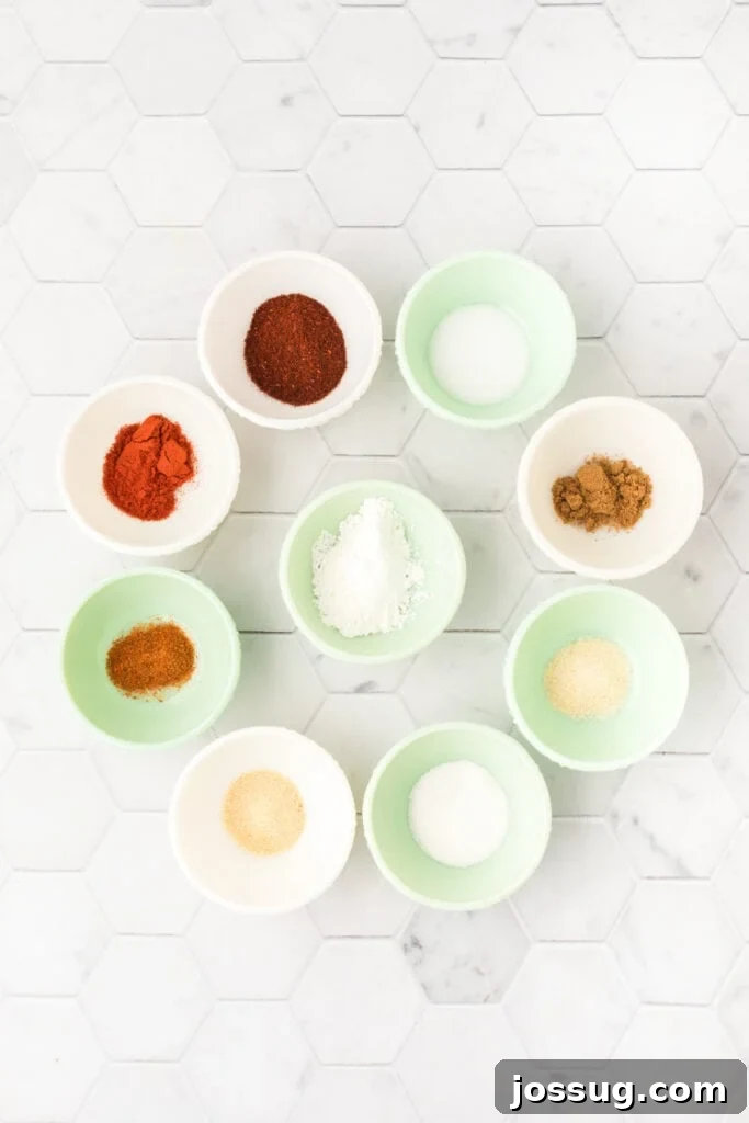 Individual spices for homemade fajita seasoning measured out into small bowls on a white countertop.
