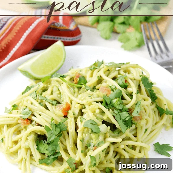 Creamy Mexican Verde Spaghetti (Espagueti Verde) 16 Guacamole Pasta on a white plate with a fork.