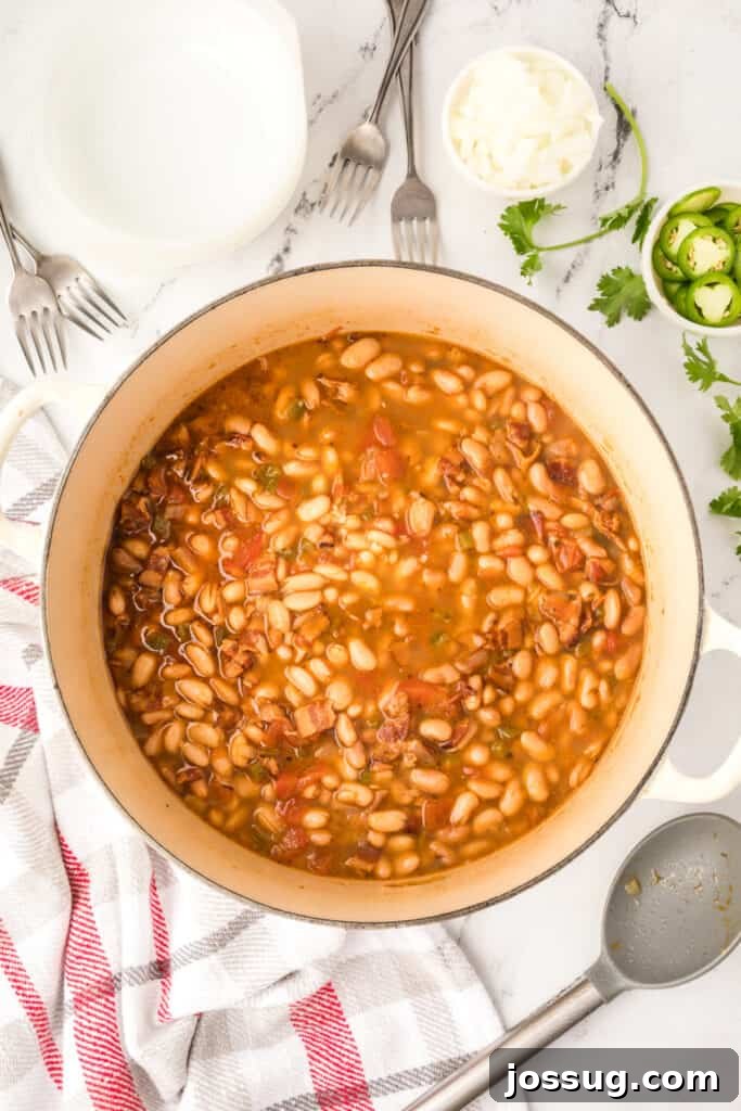 Ranchero Pinto Beans with Bacon — Flavorful Skillet Recipe 2 Finished Ranchero Beans in a Dutch oven with jalapeño slices, cilantro, and chopped onion for serving