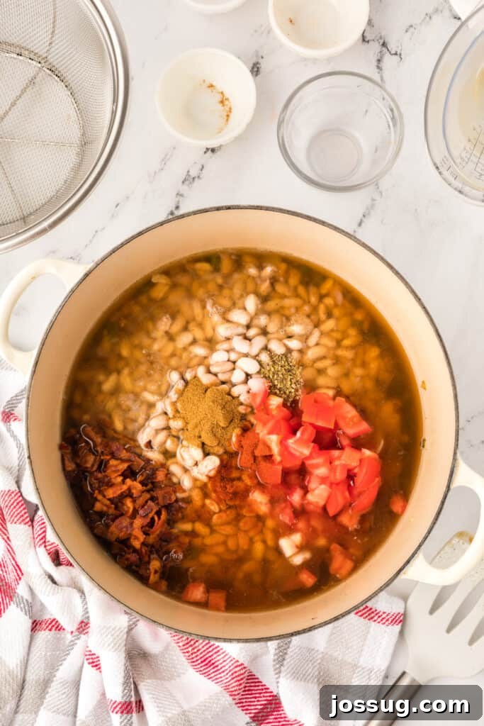 Ranchero Pinto Beans with Bacon — Flavorful Skillet Recipe 12 Ranchero Beans simmering in a Dutch oven with bacon and tomatoes