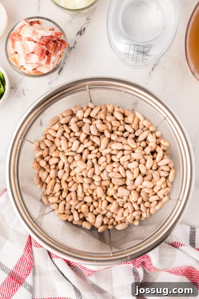 Ranchero Pinto Beans with Bacon — Flavorful Skillet Recipe 6 Soaked pinto beans draining in a colander for Ranchero Beans