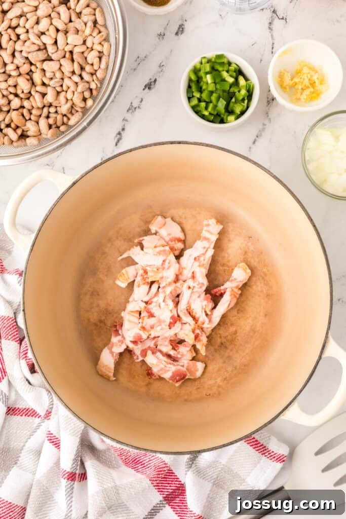 Ranchero Pinto Beans with Bacon — Flavorful Skillet Recipe 7 Bacon cooking in a Dutch oven for Ranchero Beans recipe