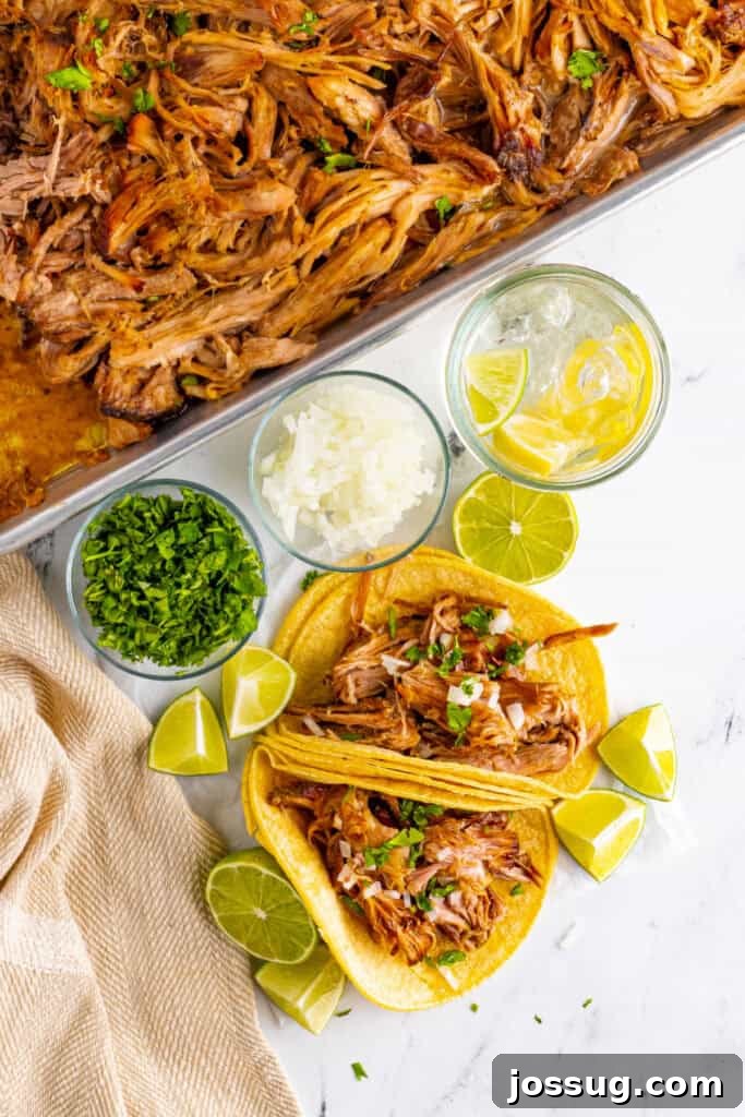 Slow Cooker Carnitas tacos with cilantro, onion, and lime wedges