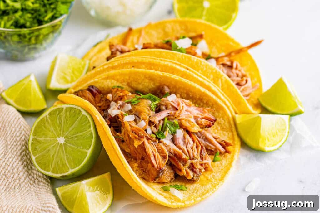 Slow Cooker Carnitas tacos with lime wedges, onion, and cilantro