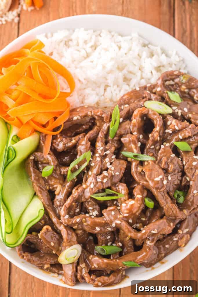 Korean Beef Bulgogi bowl served with white rice, carrot ribbons, cucumber ribbons, sesame seeds, and green onions