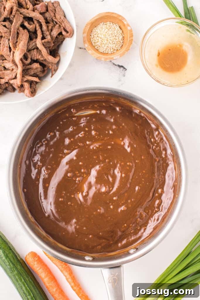 Cooked beef strips returned to thickened bulgogi sauce in a skillet for Korean Beef Bulgogi